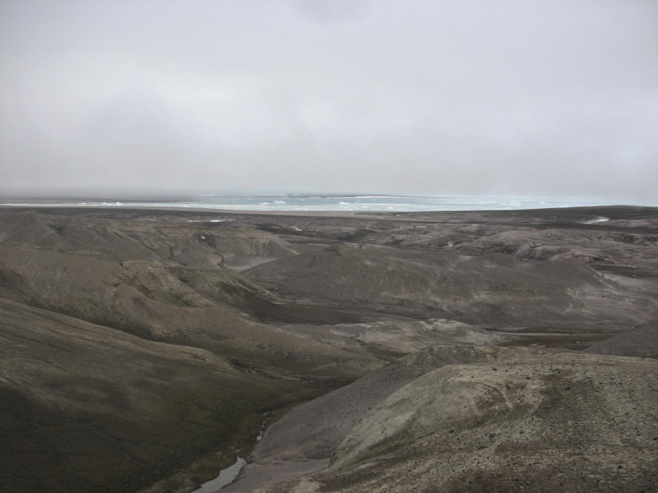 This 2006 photo provided by researchers shows the landscape at Kap Kobenhavn, Greenland. The many hills have been formed by rivers running towards the coast. Scientists have analyzed 2-million-year-old DNA extracted from dirt samples in the area, revealing an ancient ecosystem unlike anything seen on Earth today, including traces of mastodons and horseshoe crabs roaming the Arctic. (Kurt H. Kjaer via AP)