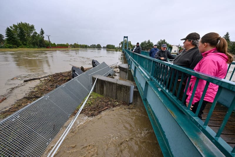 People look at a burnt pier stuck in a bridge over the Morava River that flows through the city, after heavy rains in the South Moravian region. Šálek Václav/CTK/dpa