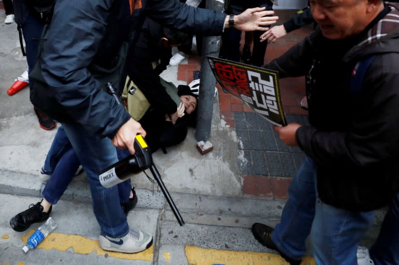 FILE PHOTO: A woman is detained by plainclothes police officers during an anti-government demonstration on New Year's Day, to call for better governance and democratic reforms in Hong Kong