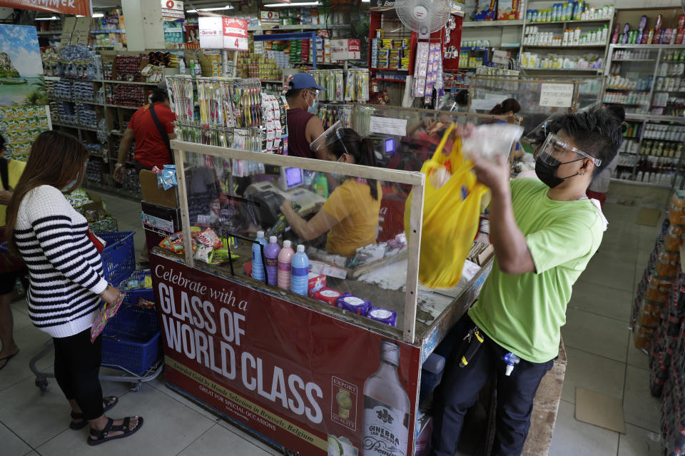 People wearing face masks and face shields to prevent the spread of the coronavirus buy at a grocery in Quezon city, Philippines as they prepare for a stricter lockdown on Sunday March 28, 2021. The government will start stricter lockdown measures next week as the country struggles to control an alarming surge in COVID-19 cases. (AP Photo/Aaron Favila)