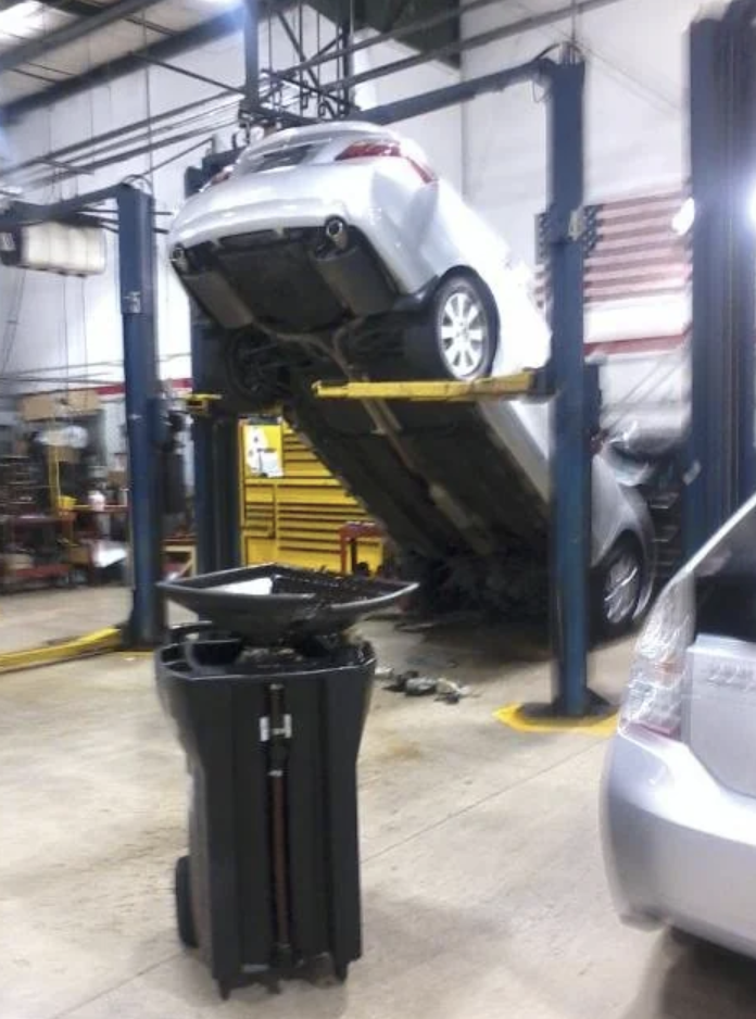 A car falling off the lift at a mechanic's shop