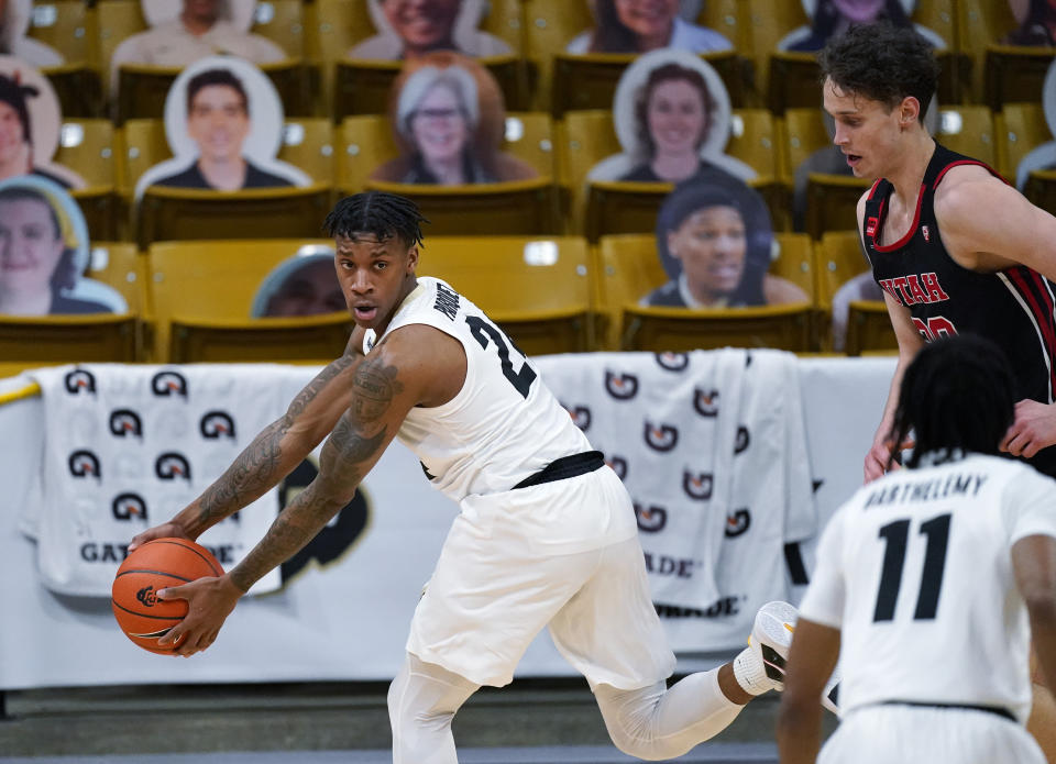 Colorado guard Eli Parquet, back left, pulls in a loose ball as Utah forward Mikael Jantunen, back right, and Colorado guard Keeshawn Barthelemy look on in the second half of an NCAA college basketball game Saturday, Jan. 30, 2021, in Boulder, Colo. Utah won 77-74. (AP Photo/David Zalubowski)