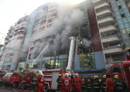 Firefighters attempt to put out fire at a market building during a fire at China town Thursday, Feb. 20, 2020, in Yangon, Myanmar. Firefighters contained a blaze in the 12-story building in the country's biggest city. (AP Photo/Thein Zaw)