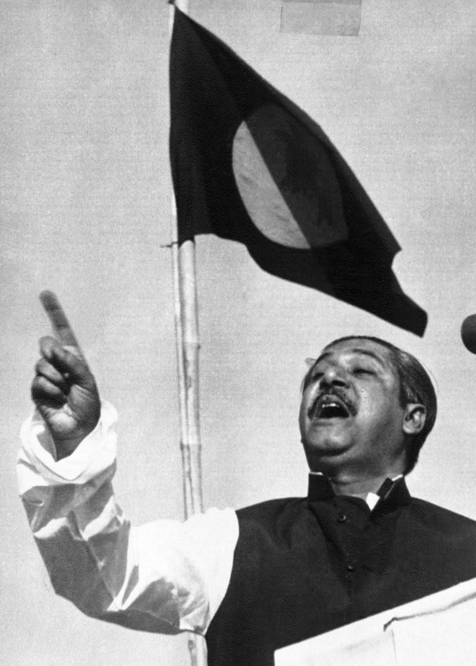 FILE - In this March 7, 1971, file photo, East Pakistan's Awami League party leader Sheikh Mujibur Rahman, addresses a mass gathering beneath the flag proposed for for a new country. At the time this photo was taken, the government in the Bengali speaking Eastern province of Pakistan was running on an informal basis under Rahman's leadership. On the day Rahman declared: “The struggle this time is for emancipation! The struggle this time is for independence!” Bangladesh is celebrating 50 years of independence this year. (AP Photo, File)