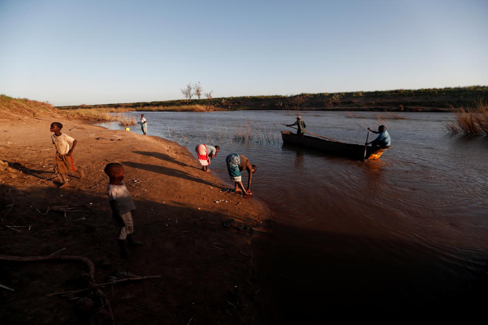 Maria Jofresse, 25, and her mother Ester Thoma wash themselves in the water of the Muda River as Maria's father Joao Jofresse, who works on a water taxi, returns from the opposite shore, in the aftermath of Cyclone Idai, in the village Cheia, which means "Flood" in Portuguese, near Beira, Mozambique April 2, 2019. (Photo: Zohra Bensemra/Reuters)  