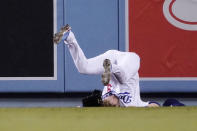 Los Angeles Dodgers second baseman Gavin Lux falls after missing a catch on a ball hit for an RBI triple by San Diego Padres' Wil Myers and running into the wall during the sixth inning of a baseball game Wednesday, Sept. 29, 2021, in Los Angeles. (AP Photo/Mark J. Terrill)