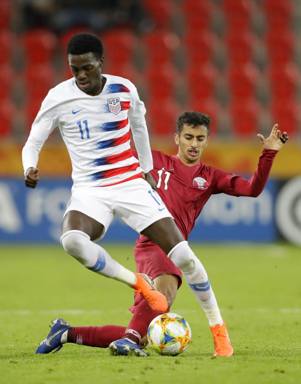 United States' Tim Weah, front, duels for the ball with Qatar's Abdulla Nasser during the Group D U20 World Cup soccer match between USA and Qatar, in Tychy, Poland, Thursday, May 30, 2019. (AP Photo/Sergei Grits)
