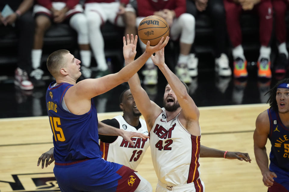 Denver Nuggets center Nikola Jokic (15) drives to the basket over Miami Heat forward Kevin Love (42) during the second half of Game 3 of the NBA Finals basketball game, Wednesday, June 7, 2023, in Miami. (AP Photo/Rebecca Blackwell)