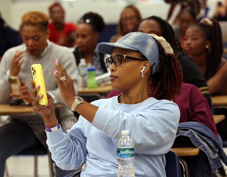 Narnike Pierre-Grant, center, pulls out her phone engage in the break-out session as during a town hall hosted by Broward County Public Schools to discuss the possibility of closing schools in 2025.