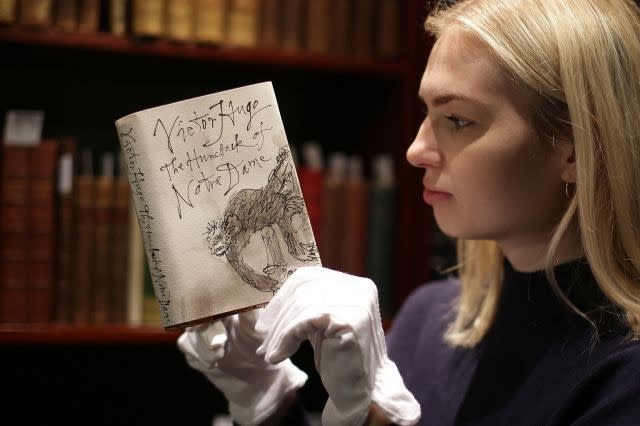 An employee holds a first edition copy of 'The Hunchback of Notre-Dame' by Victor Hugo with a dust-jacket designed by Quentin Blake