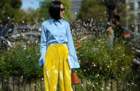 <p>Mindestens ein Statement setzte auch Yoyo Cao. Die Stilikone kombinierte eine hellblaue Bluse zur gelben Samthose – und leitete damit nicht nur einen neuen Trend, sondern auch direkt den Frühling im Oktober ein. (Bild: REX/ Shutterstock)</p>