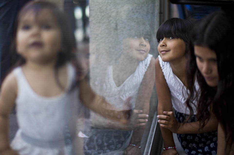 In this Dec.15, 2018 photo, Emma, a transgender student of the Amaranta Gomez school plays with her sisters while she waits to update her identity card at the national registry of persons, in Santiago, Chile. After suffering years of discrimination some 20 transgender minors aged 6 to 17 have recently found hope at Latin America's first school for trans children. (AP Photo/Esteban Felix)