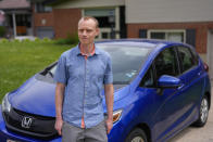 Caleb Jud, 33, poses for a portrait with his Honda Fit, Monday, May 13, 2024, in Cincinnati. Many Americans still aren’t sold on going electric for their next car purchase. High prices and a lack of easy-to-find charging stations are major sticking points, a new poll shows(. Jud said he’s considering an EV, but may end up with a plug-in hybrid — if he goes electric. (AP Photo/Joshua A. Bickel)