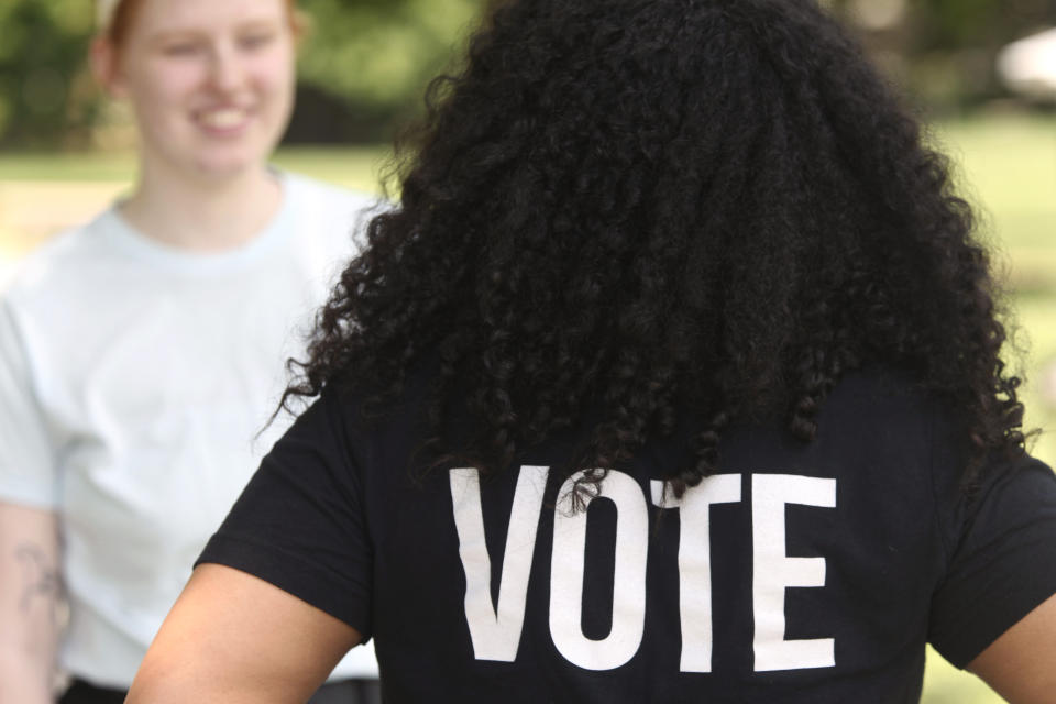 Anita Alexander, vice president for the Kansas group Loud Light, wears a T-shirt encouraging voting on the campus of Washburn University, Friday, May 18, 2024, in Topeka, Kan. Their group does voter registration drives on college campuses but has suspended that work while it challenges a state elections law that it says hampers registration drives. Laws passed in several Republican-controlled states are making it challenging for advocates to adapt as they try to register and educate potential voters with just months to go before the presidential election. (AP Photo/John Hanna)