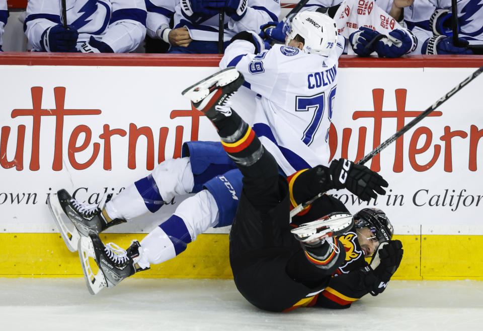 Tampa Bay Lightning forward Ross Colton, left, checks Calgary Flames forward Nazem Kadri during the second period of an NHL hockey game in Calgary, Alberta, Saturday, Jan. 21, 2023. (Jeff McIntosh/The Canadian Press via AP)