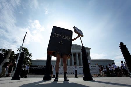 A protester dressed as a copy of the Bible joins groups demonstrating outside the U.S. Supreme Court in Washington June 30, 2014. REUTERS/Jonathan Ernst