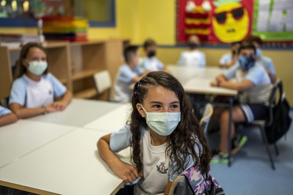 Pupils wearing a face mask to protect against the spread of coronavirus attend a class at Maestro Padilla school as the new school year begins, in Madrid, Spain, Tuesday, Sept. 7, 2021. Around 8 million children in Spain are set to start the new school year. (AP Photo/Manu Fernandez)