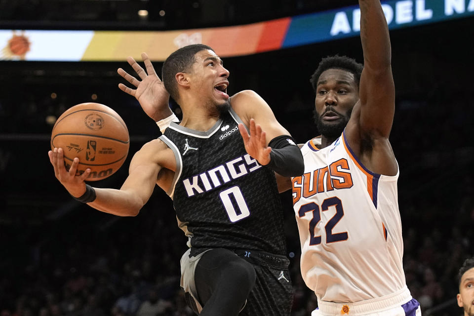 Sacramento Kings guard Tyrese Haliburton drives on Phoenix Suns center Deandre Ayton (22) during the first half of an NBA basketball game, Wednesday, Oct. 27, 2021, in Phoenix. (AP Photo/Rick Scuteri)