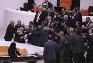 Lawmakers push earn other at the parliament, in Ankara, Turkey, Tuesday, Dec. 6, 2022. Huseyin Ors, a lawmaker from the opposition Good Party, was hospitalized on Tuesday following a brawl that broke out in Turkey's parliament during a tense debate over next year's budget. (AP Photo)