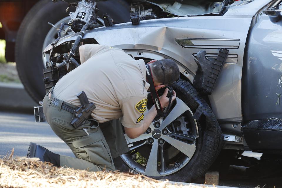 <p>A sheriff’s deputy examines the SUV crashed by Tiger Woods last week</p> (EPA)