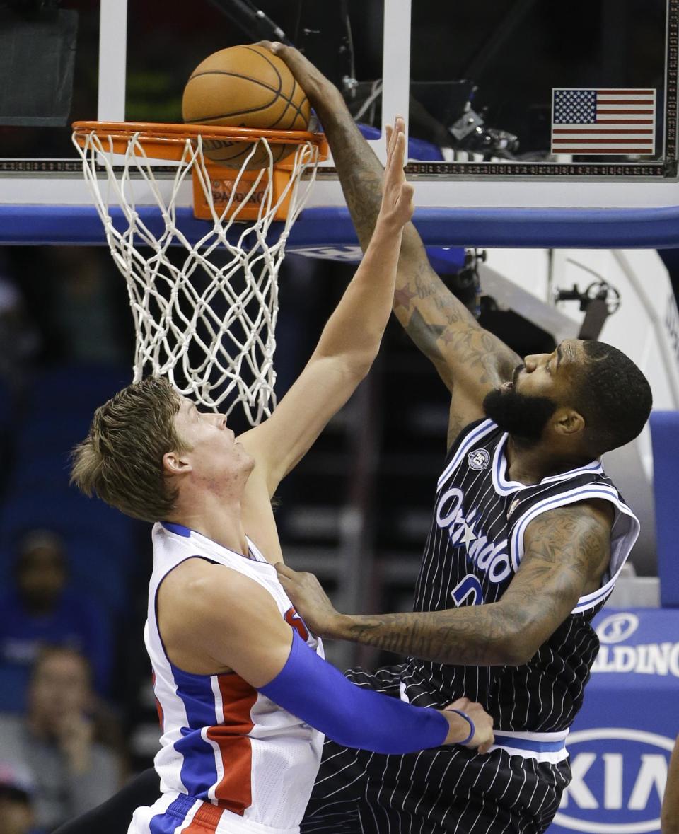 Orlando Magic's Kyle O'Quinn, right, dunks as he gets past Detroit Pistons' Jonas Jerebko during the first half of an NBA basketball game in Orlando, Fla., Wednesday, Feb. 5, 2014. (AP Photo/John Raoux)