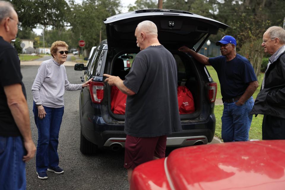 In Hastings, 93-year-old Mary Alice Wolfe, Johnny Barnes, center, and other volunteers Chris Stanton, from left, Lee Waddell and the Rev. David MacFarland prep for a food delivery for St. Johns County seniors in need.