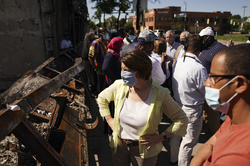 Sen. Amy Klobuchar surveys damage while meeting with business owners that were affected by events following the George Floyd protests Friday, June 5, 2020 at Hawthorne Crossings in north Minneapolis. Floyd died after being restrained by Minneapolis police officers on May 25. (Anthony Souffle/Star Tribune via AP)