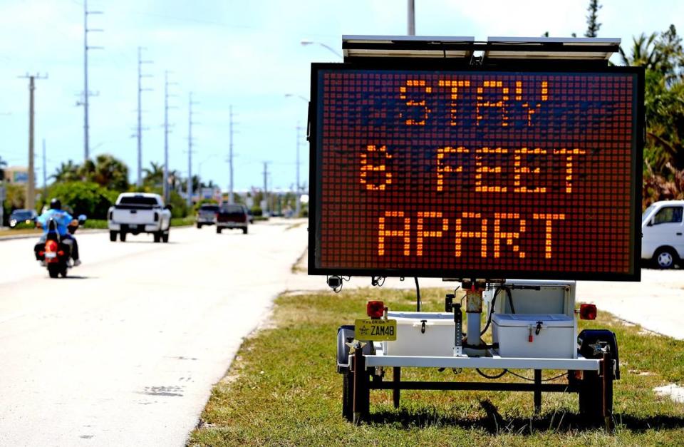 Signs along U.S. 1 in Marathon in the Florida Keys ask drivers to practice social distancing as the Keys prepare to shut down on Sunday closing hotels and restaurants because of coronavirus fears, March 21, 2020.