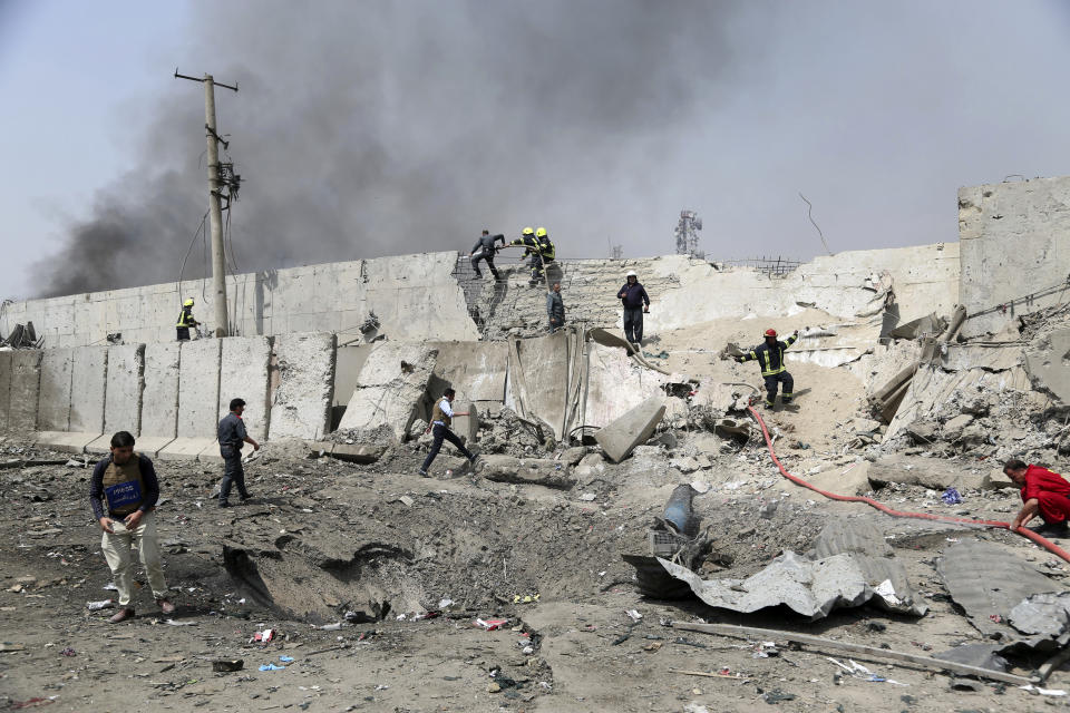 Afghan firefighters work at the site of Monday's suicide bomb attack in Kabul, Afghanistan, Tuesday, Sept. 3, 2019. (AP Photo/Rahmat Gul)