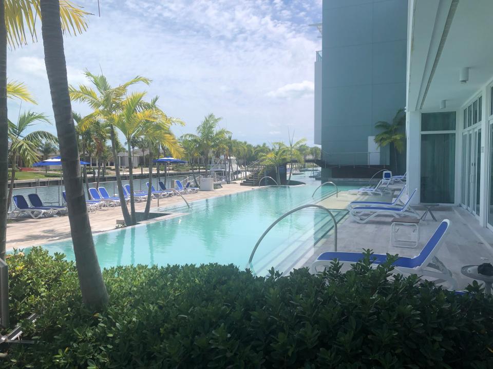 A large and clean-looking outdoor pool at the Hilton hotel in Bimini with empty chairs