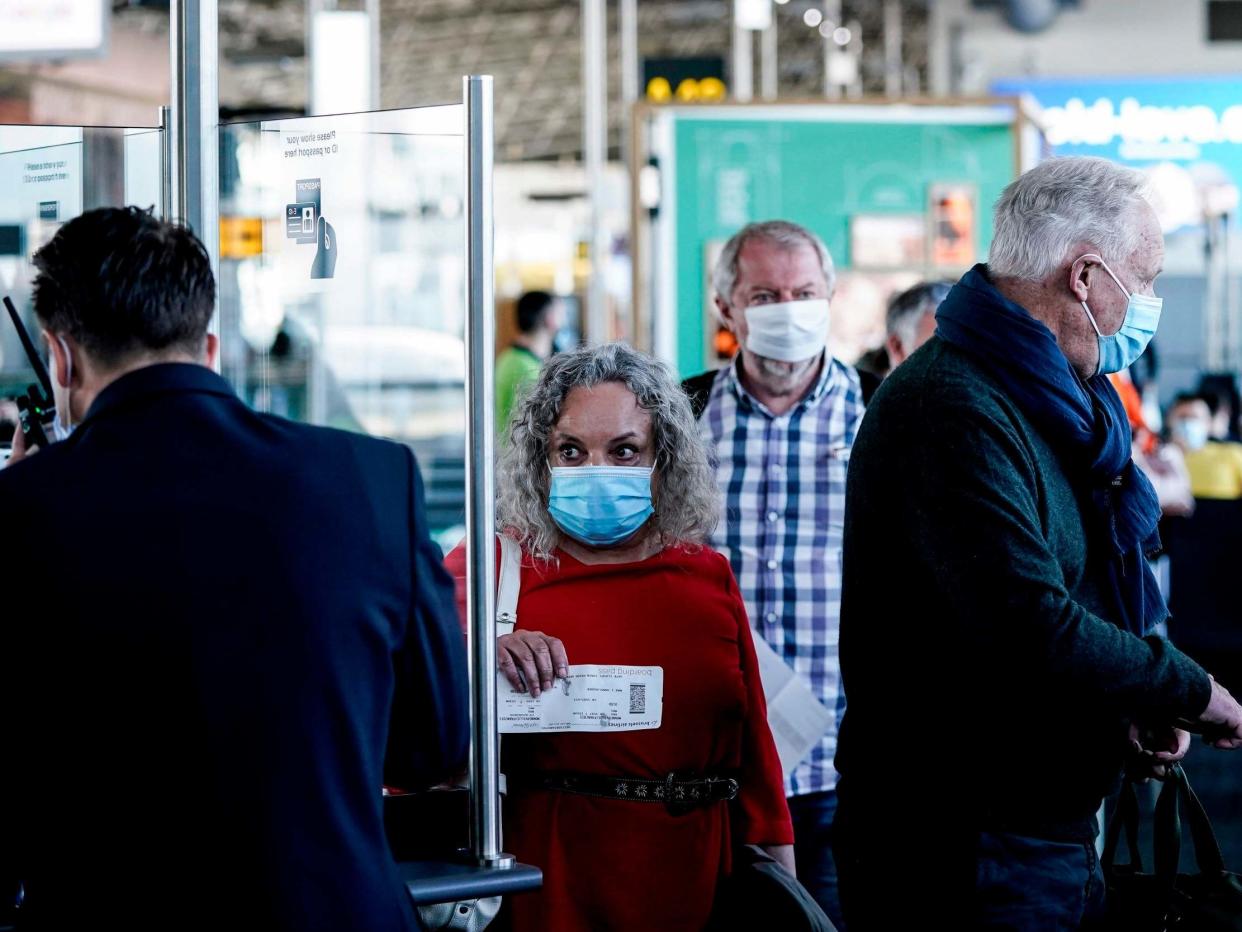 Passengers wearing protective face masks queue at the boarding gate at Brussels Airport, in Zaventem: Kenzo Tribouillard/AFP via Getty Images