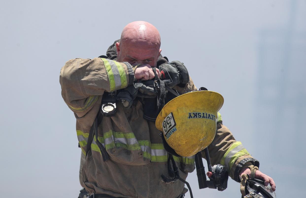 A firefigher wipes his face after battling a July 18 fire that destroyed mobile homes at the Country Squire RV and Mobile Home Park in Desert Hot Springs.