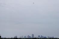 Archbishop Gregory Aymond rides in a World War II era Stearman PT-17 biplane over the city of New Orleans, Friday, April 10, 2020. He took with him holy water from the Jordan River, where Christ was baptized, to sprinkle over the city, and the Eucharist, to bless those sick or deceased from the new coronavirus, as well as the front line responders. (AP Photo/Gerald Herbert)