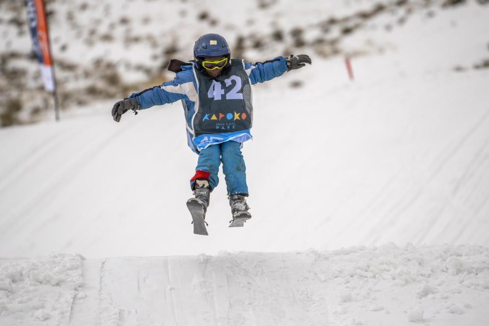 John Bokang competes in the youth category of the Winter Whip Slopestyle snowboard and ski competition at the Afriski ski resort near Butha-Buthe, Lesotho, Saturday July 30, 2022. While millions across Europe sweat through a summer of record-breaking heat, Afriski in the Maluti Mountains is Africa's only operating ski resort south of the equator. It draws people from neighboring South Africa and further afield by offering a unique experience to go skiing in southern Africa. (AP Photo/Jerome Delay)