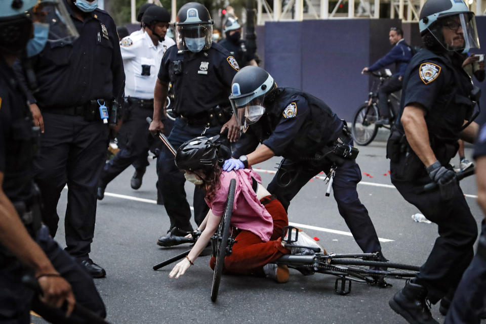 FILE — In this June 3, 2020 file photo, a protester is arrested by NYPD officers for violating curfew beside New York's iconic Plaza Hotel, following the death of George Floyd, who died after being restrained by Minneapolis police officers. The New York Police Department was caught off guard by the size and scope of the spring protests sparked by the police killing of George Floyd in Minneapolis and resorted to disorder control tactics that stoked tensions and stifled free speech rights, the city's inspector general said in a report released Friday, Dec. 18, 2020.(AP Photo/John Minchillo, File)