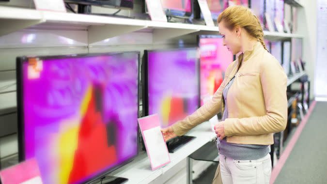 The woman buys a TV in shop.