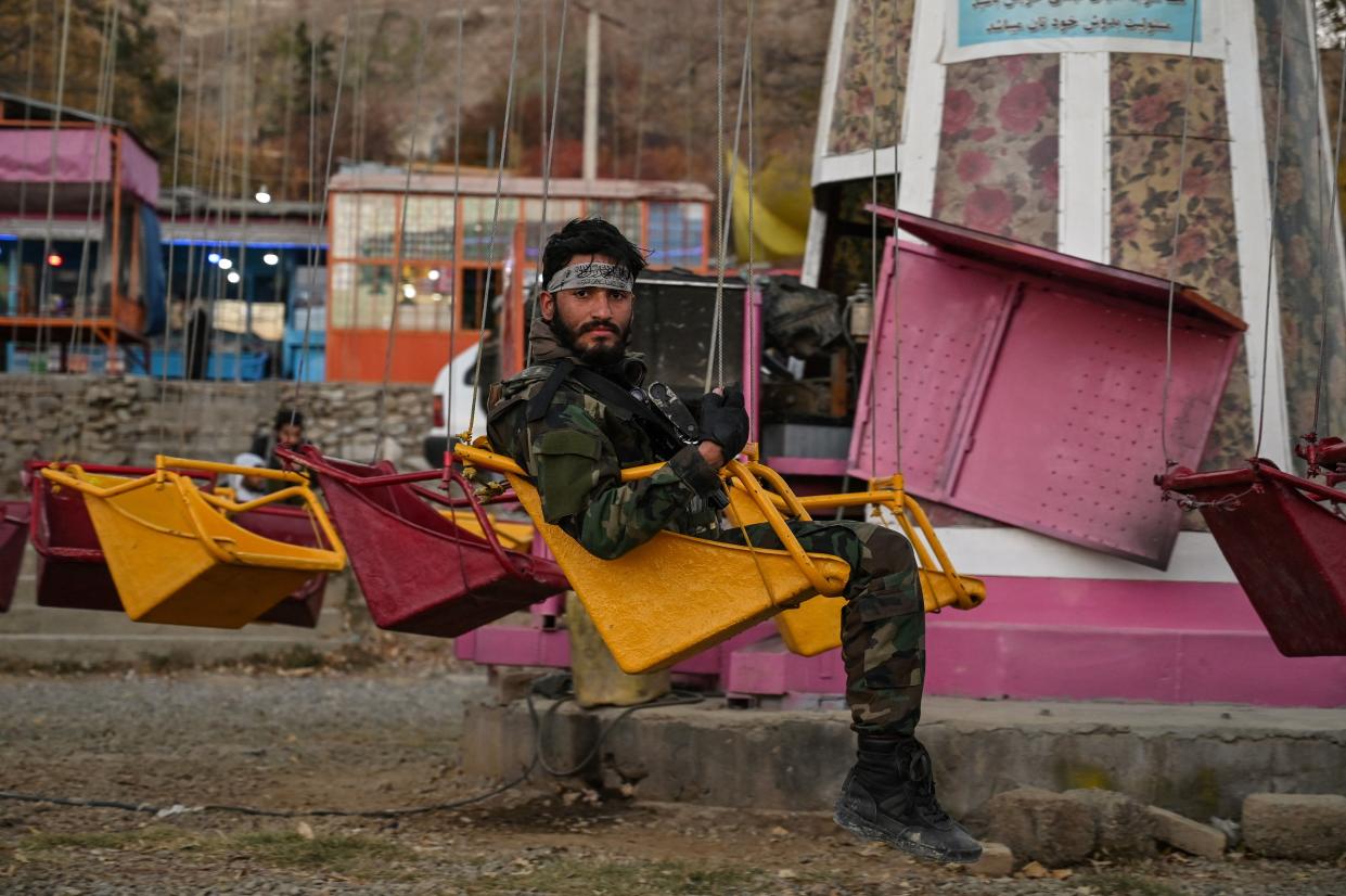 In this picture taken on November 19, 2021 A Taliban fighter sits on a ride during a visit to an amusement park next to the Qargha Lake on the outskirts of Kabul.