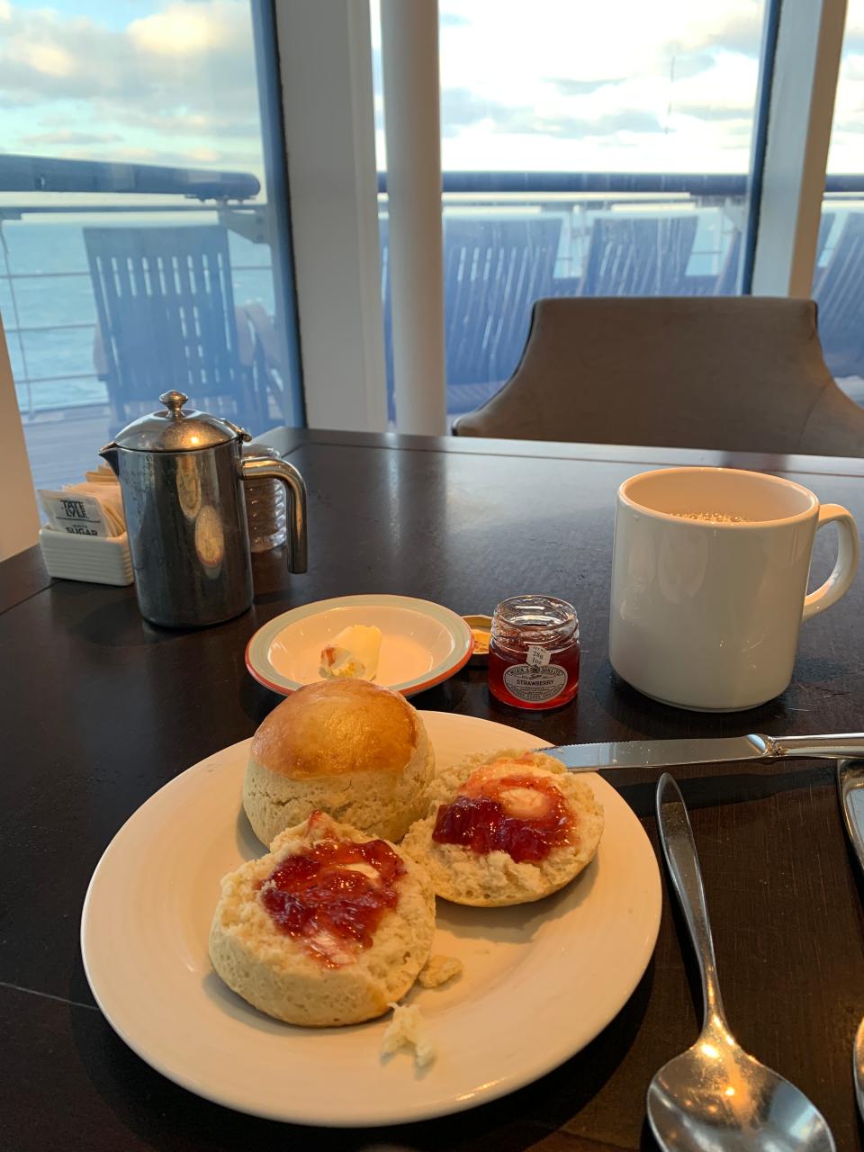 Tea and scones with clotted cream and strawberry jam on board the Queen Mary 2. Tea is served at 3:30 each afternoon.