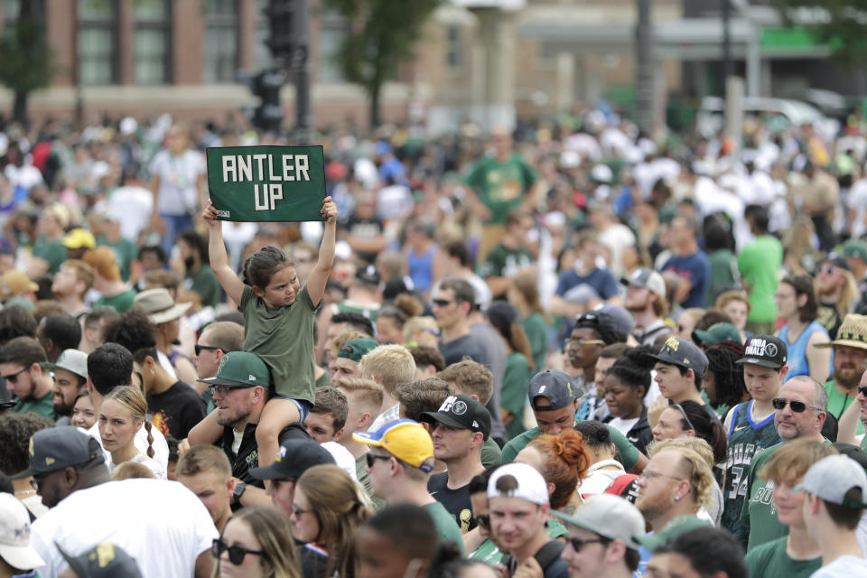 Una niña alza un cartel de apoyo a los Bucks durante un desfile por las calles de Milwaukee por la conquista del título de la NBA, el jueves 22 de julio de 2021. (AP Foto/Aaron Gash)