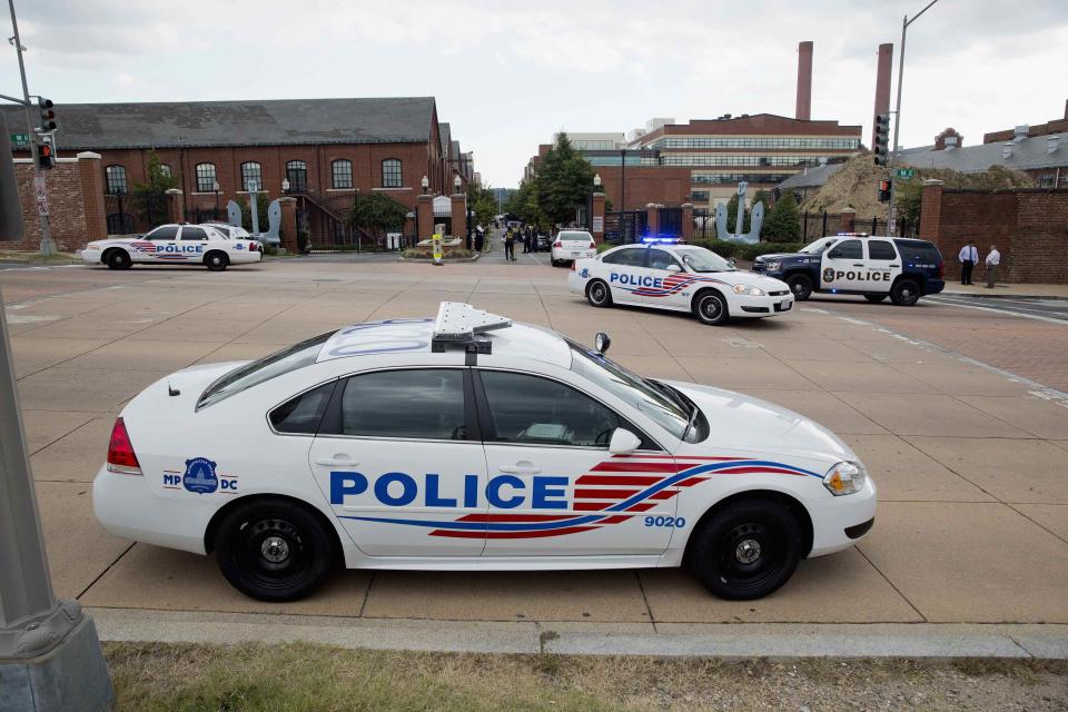 Police cars are parked outside the U.S. Navy Yard after a shooting in Washington September 16, 2013. (REUTERS/Joshua Roberts)