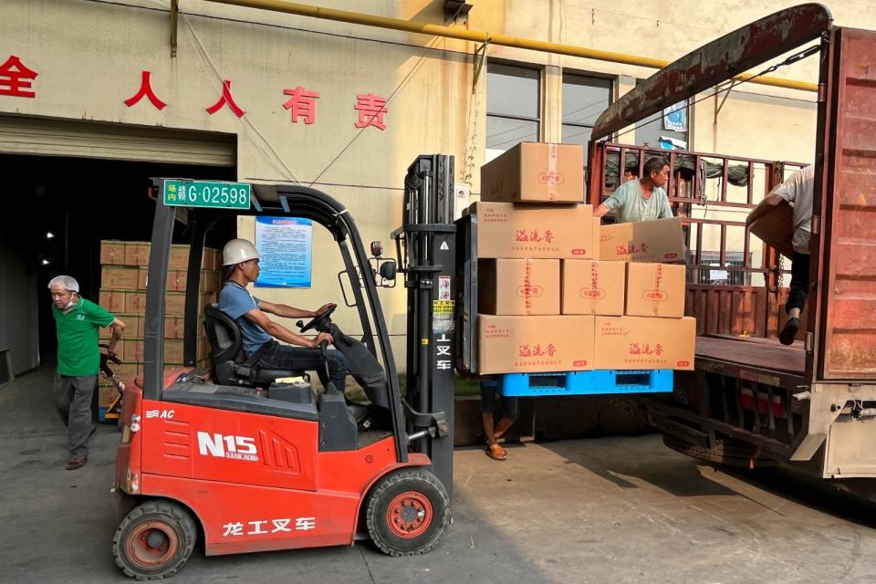瑞昌溢香農產品工廠工人用起貨機搬貨。路透社
