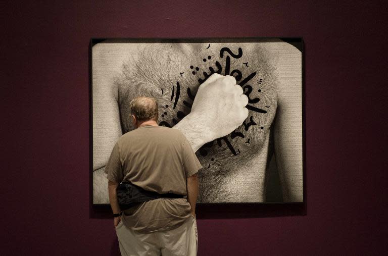 A man views "My House is On Fire" from The Book of Kings series, 2012, by Iranian-born visual artist Shirin Neshat during the exhibit's public opening at the Hirschhorn Art Museum in Washington, DC, May 18, 2015