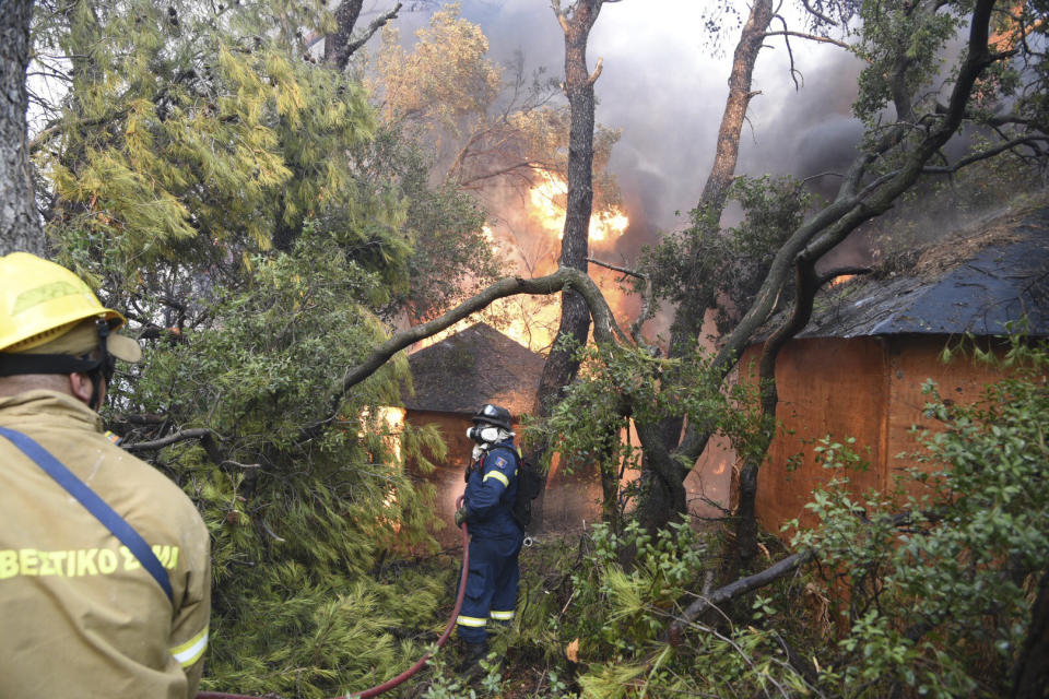 Firefighters operate during a wildfire near Lampiri village, west of Patras, Greece, Saturday, Jul. 31, 2021. The fire, which started high up on a mountain slope, has moved dangerously close to seaside towns and the Fire Service has send a boat to help in a possible evacuation of people. (AP Photo/Andreas Alexopoulos)