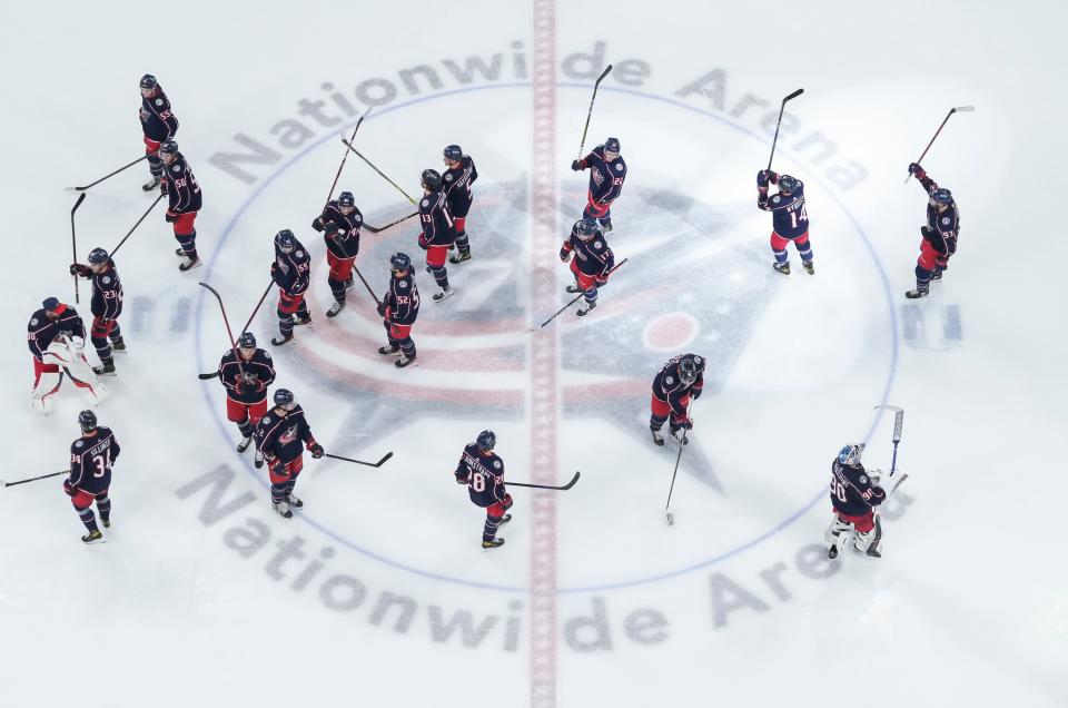 Columbus Blue Jackets players raise their sticks to salute the fans following the final home game at Nationwide Arena in Columbus on April 28, 2022. The Blue Jackets beat the Tampa Bay Lightning 5-2.