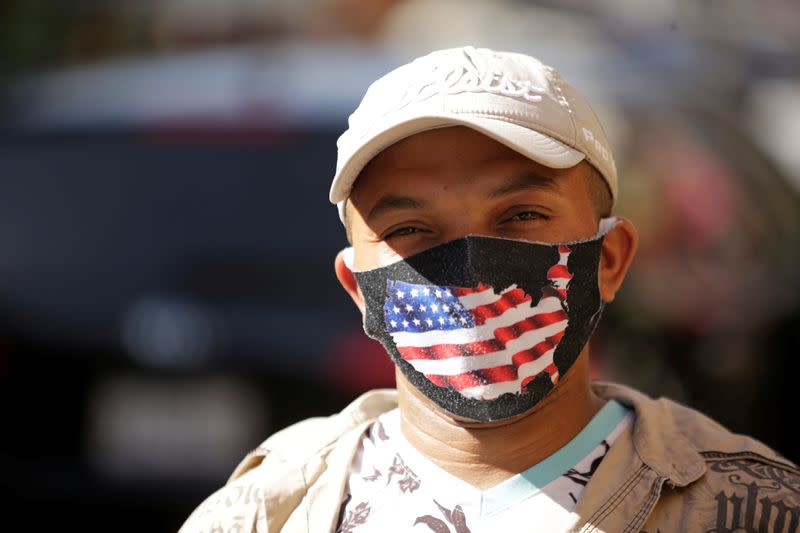 A cuban migrant wearing face mask reacts after media announced that Democratic U.S. presidential nominee Joe Biden has won the 2020 U.S. presidential election in Ciudad Juarez
