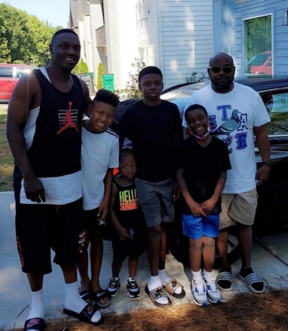 Zaire Person poses with his father, Devonye Person, grandfather, Devon Patterson, and brothers.