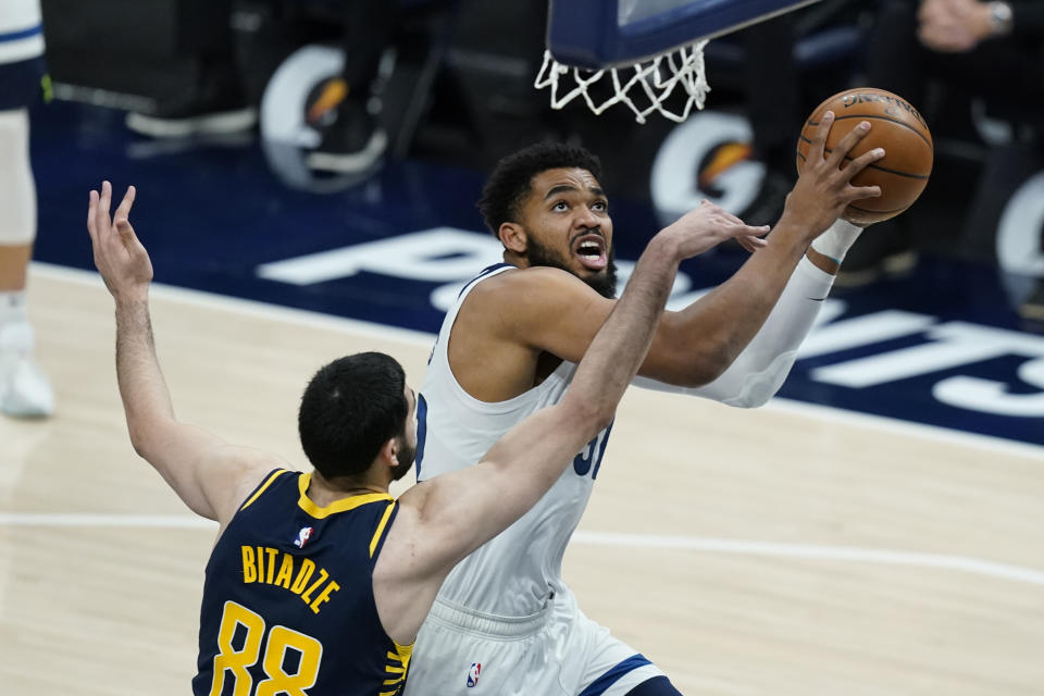 Minnesota Timberwolves' Karl-Anthony Towns (32) is fouled by Indiana Pacers' Goga Bitadze (88) as he goes up for a shot during the first half of an NBA basketball game, Wednesday, April 7, 2021, in Indianapolis. (AP Photo/Darron Cummings)