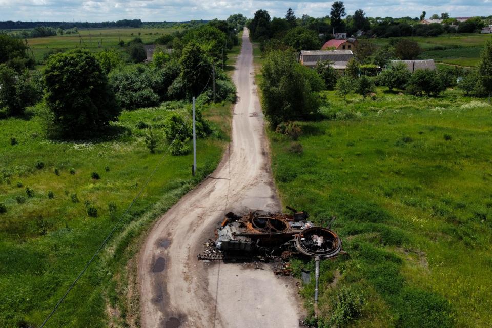 A ruined tank remains on a road in Lypivka, on the outskirts of Kyiv, Ukraine, Tuesday, June 14, 2022. Russia’s invasion of Ukraine is spreading a deadly litter of mines, bombs and other explosive devices that will endanger civilian lives and limbs long after the fighting stops. 
