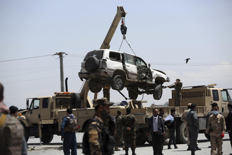 A damaged vehicle is removed from the site of a bomb explosion in Kabul, Afghanistan, Monday, April 27, 2020. Kabul police said a sticky bomb attached to a vehicle detonated in the capital but caused no casualties. (AP Photo/Rahmat Gul)