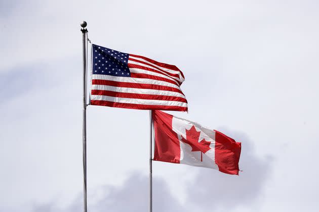 U.S. and Canadian flags fly atop the Peace Arch at the Canada-U.S. border on May 17, 2020. 